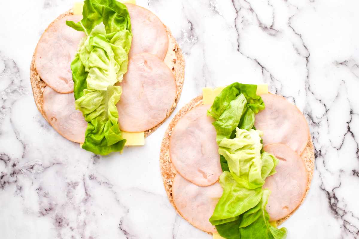 smoked turkey slices, and lettuce on cream cheese covered flour wraps.