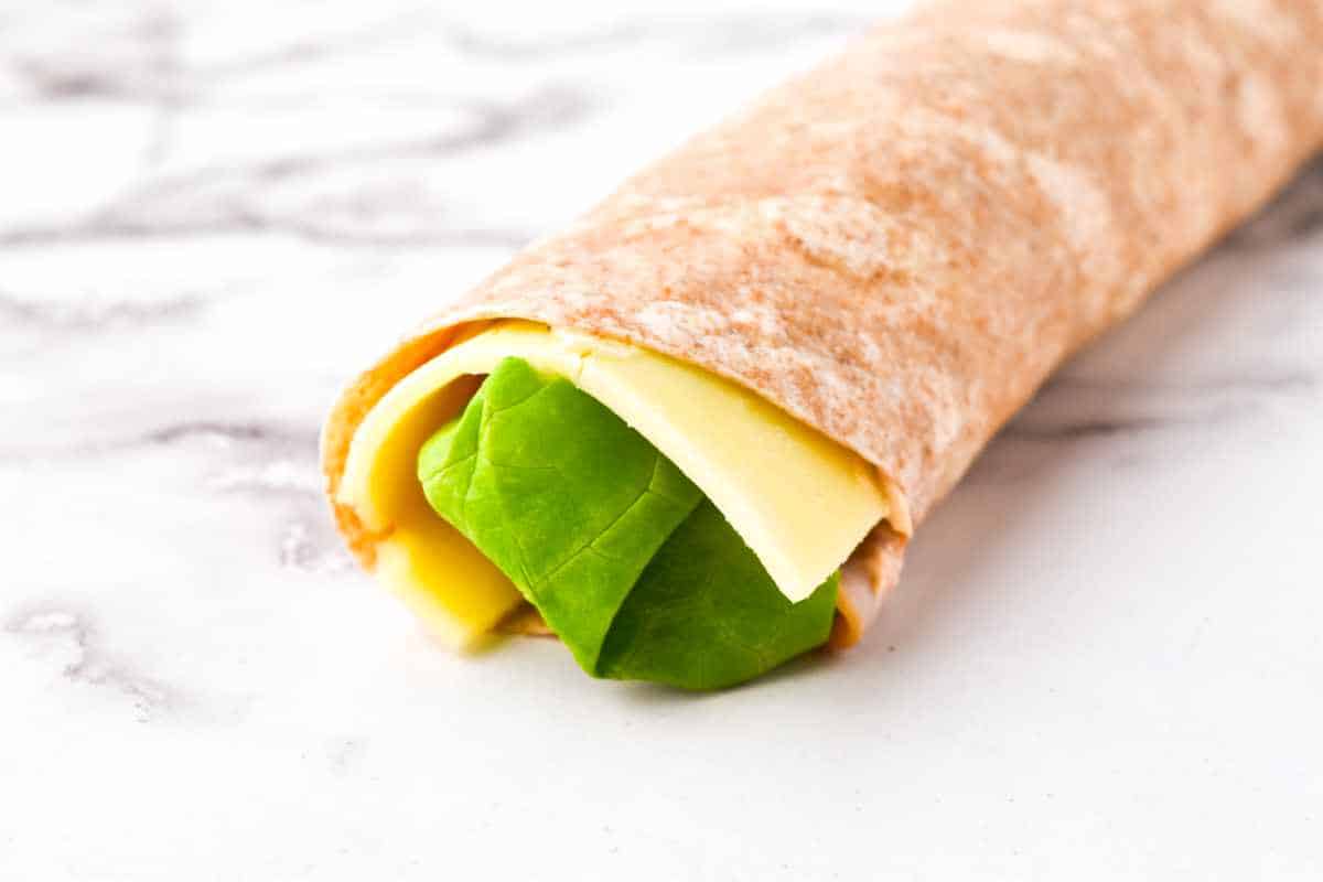 rolled up wrap with cheese and lettuce.