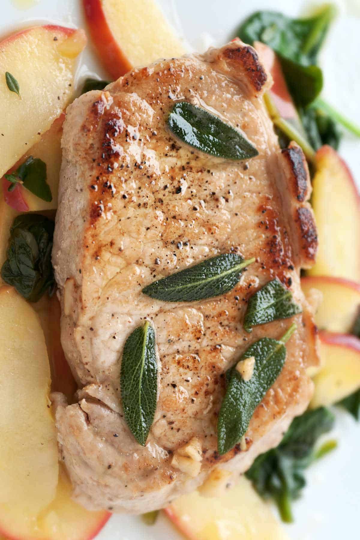 Golden pork chop with warm apple and green salad.