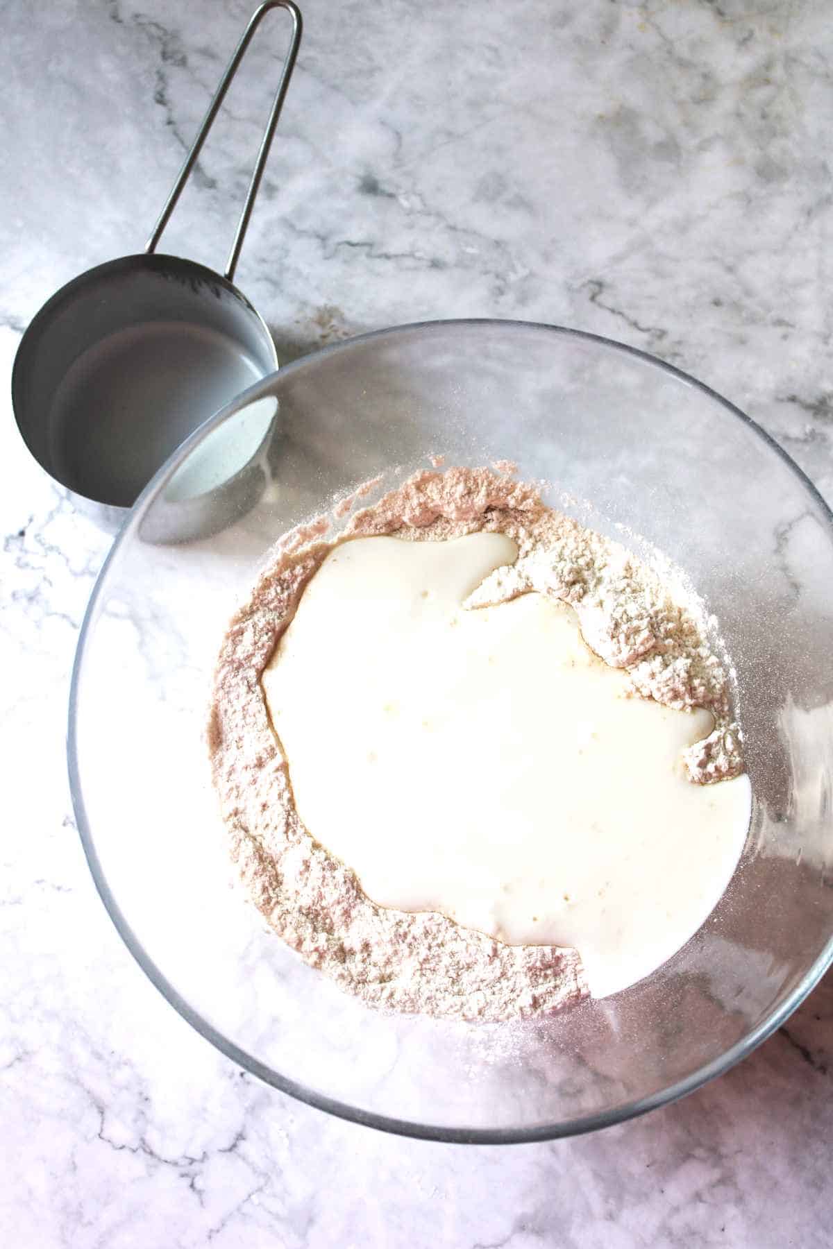 flour, milk and yeast in a bowl.
