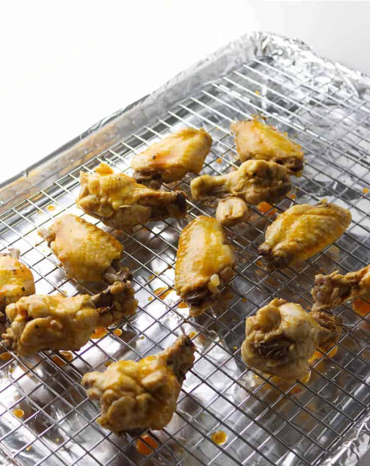 prepared chicken wings with barbeque sauce on a foil lined baking sheet