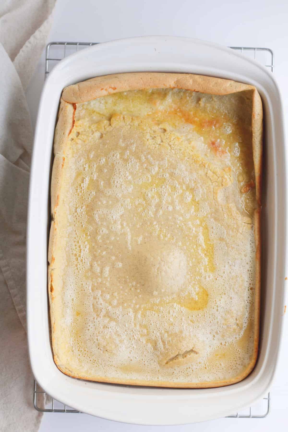 white casserole dish with baked puff pancake inside