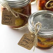 display of four ball canning jars filled with tomato confit and hang tags for gift giving