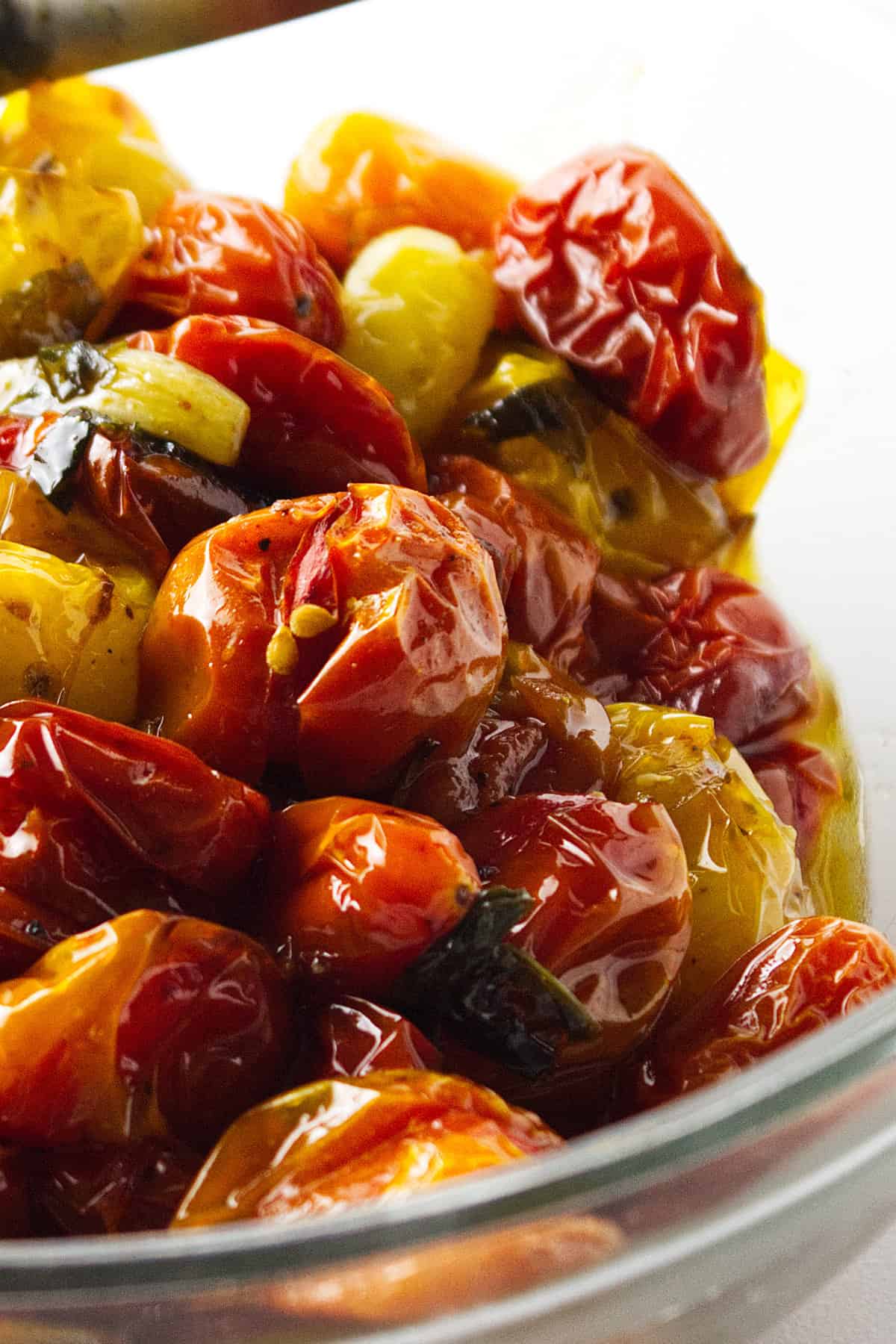 clear glass bowl of roasted heirloom cherry tomatoes.