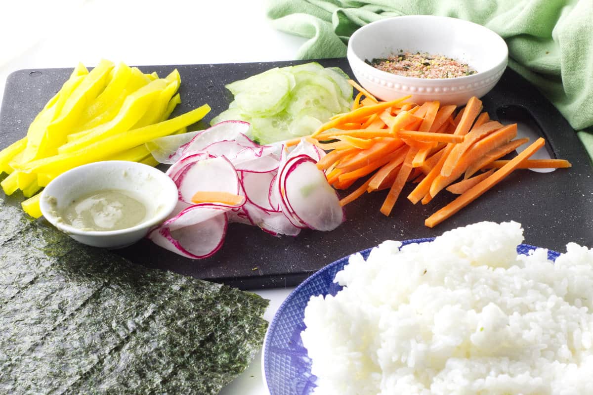 slivers of carrot, radish, cucumber, and a bowl of rice for Korean 'Sushi' Rolls.