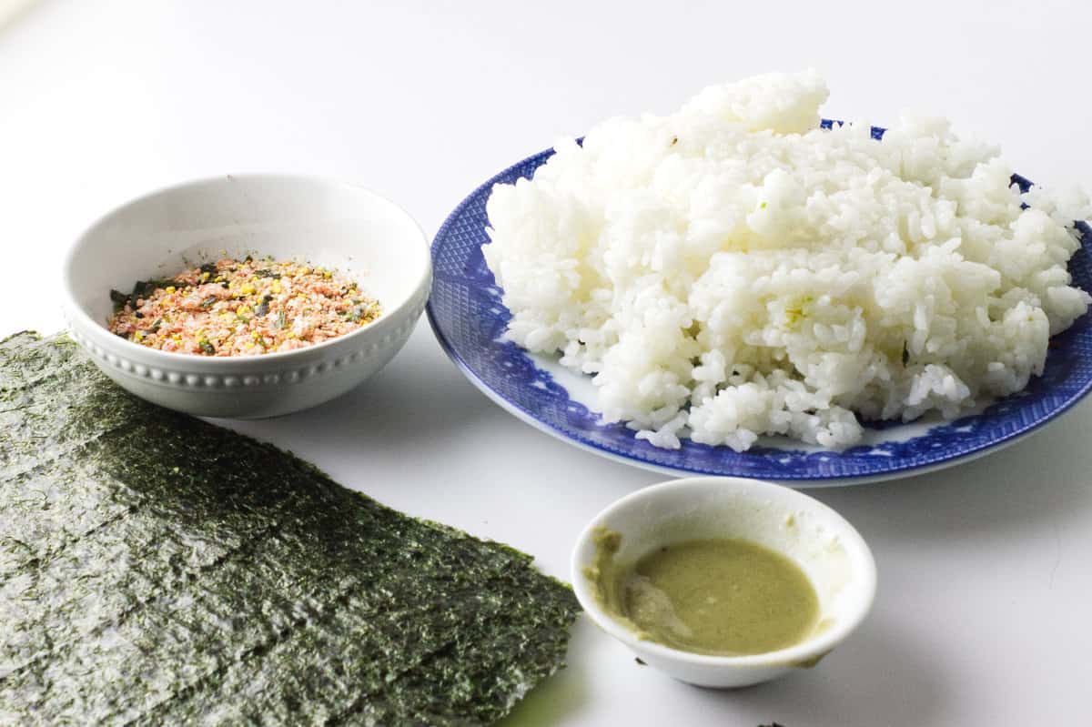 ingredients in bowls: white sushi rice, wasabi, and furikake to make korean sushi roll.