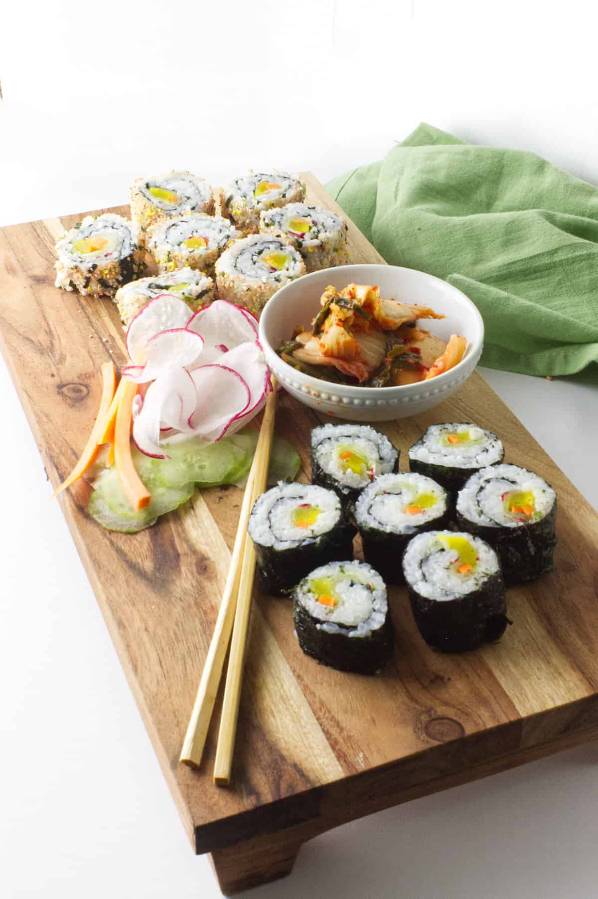 Korean 'Sushi' Rolls on a wood platter with chop sticks and kimchi.