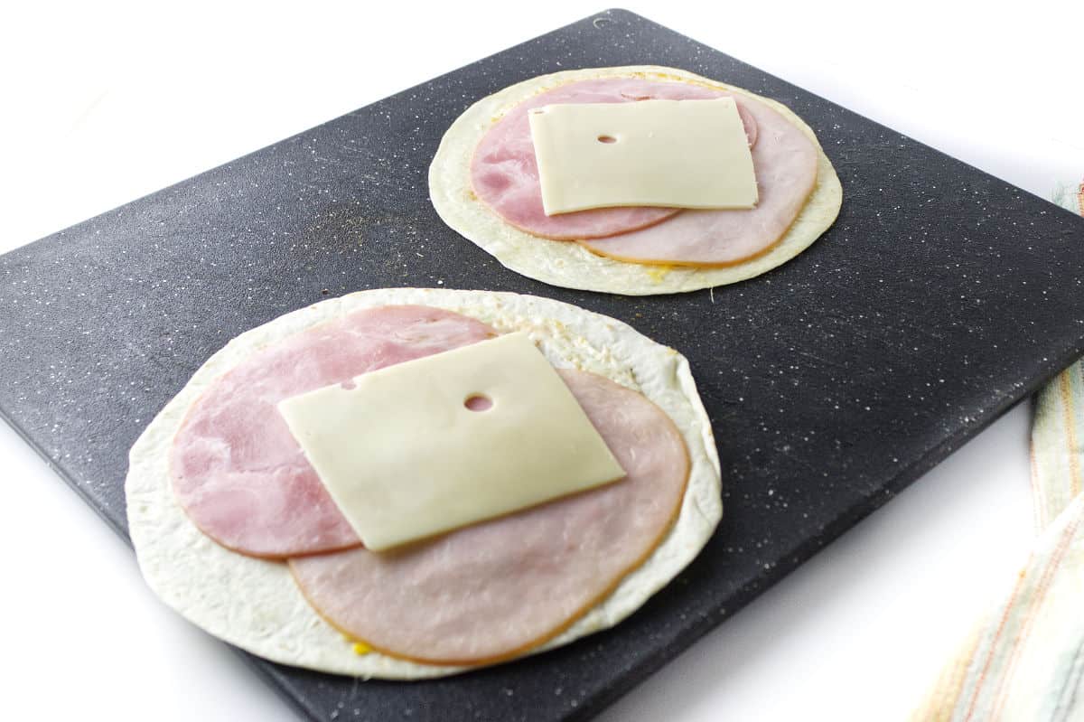two flour tortillas with turkey, ham, and swiss cheese.