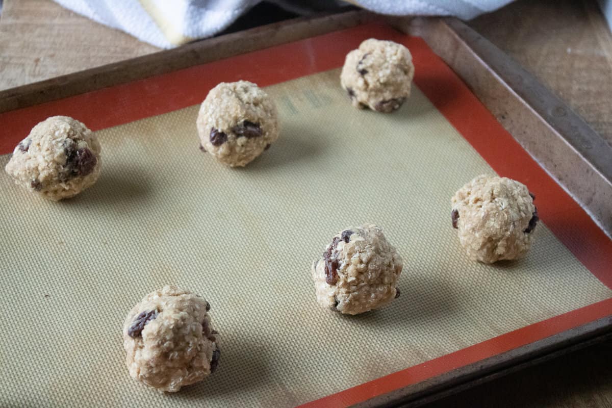 balls of cookie dough on a silpat covered baking tray.