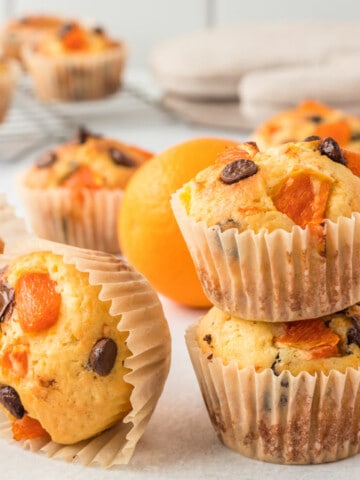 orange and chocolate chip muffins on a white background.
