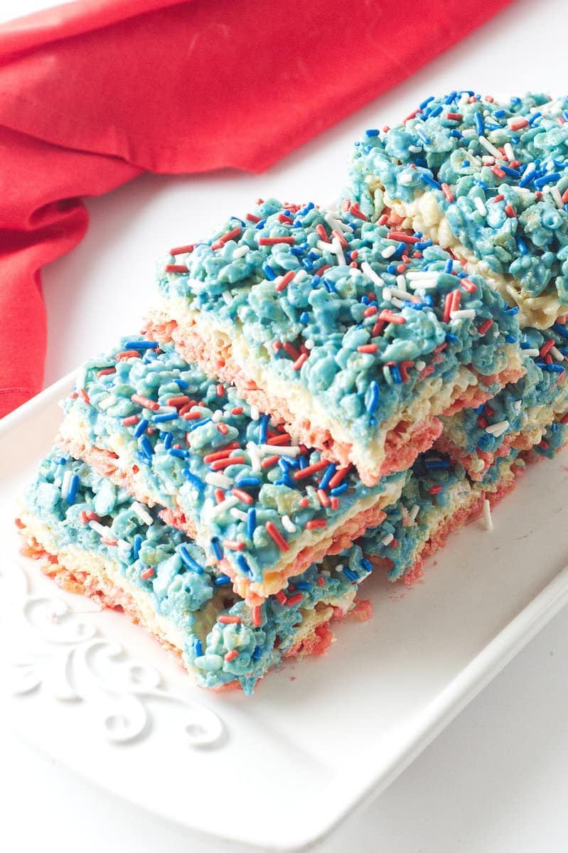 white tray full of 4th of July rice crispy treats with sprinkles on top.