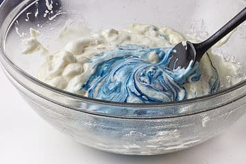 blue colored marshmallow mixture in a clear glass bowl.