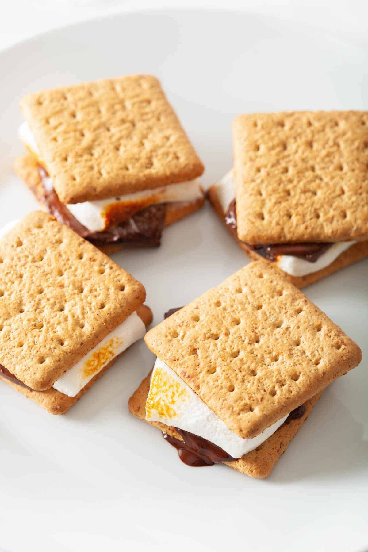 four s'mores on a light blue plate.