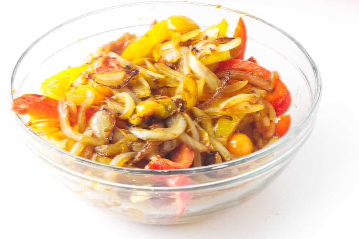 rainbow bell pepers and onion cooked and in a bowl.