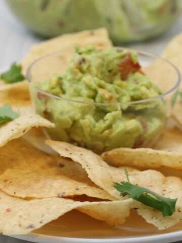 guacamole with tortilla chips on a platter.