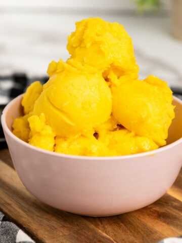 white bowl with scoops of yellow sorbet.