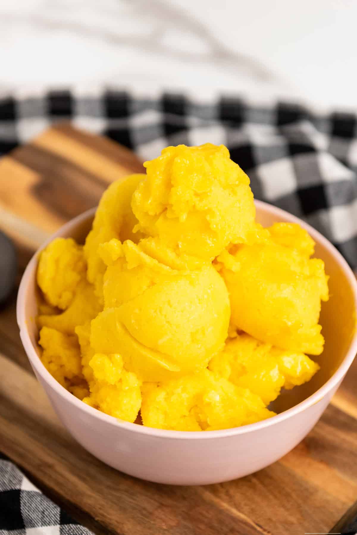 big scoops of yellow sugar free sorbet in a bowl.