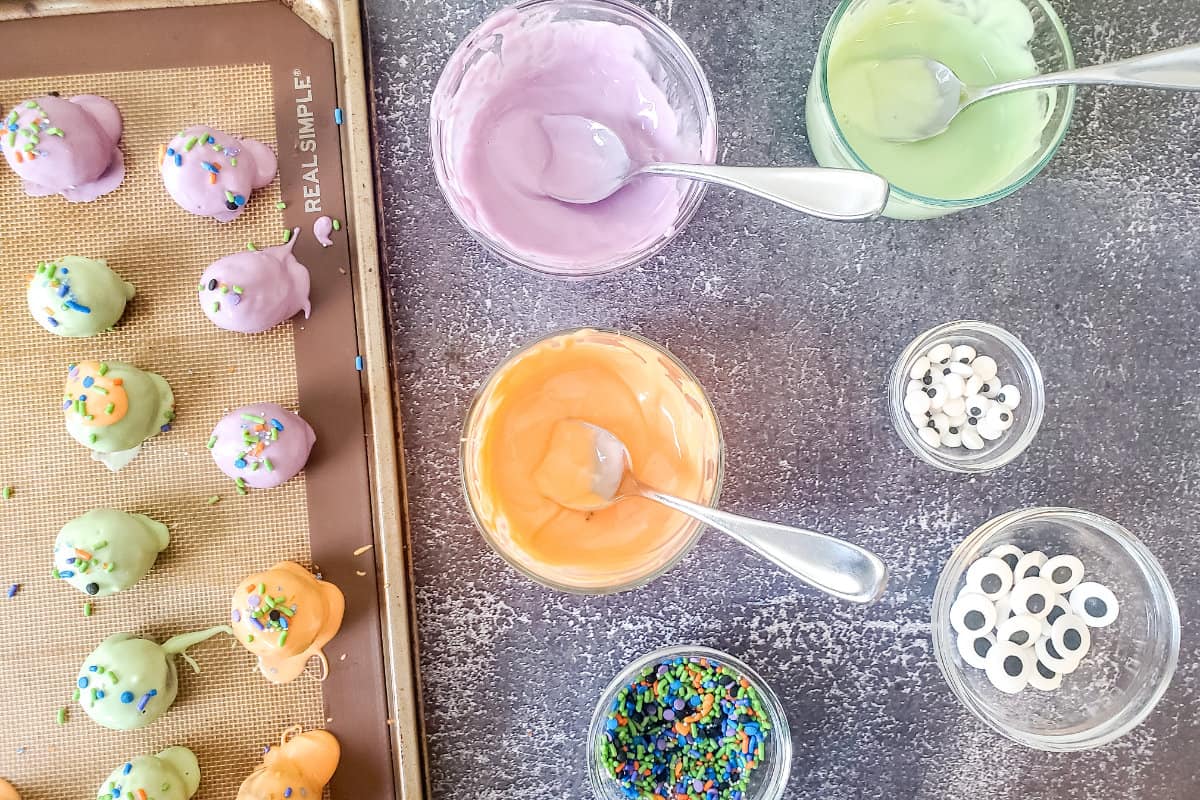dipping cold oreo truffles in lavender, green, and orange candy melted mixtures.