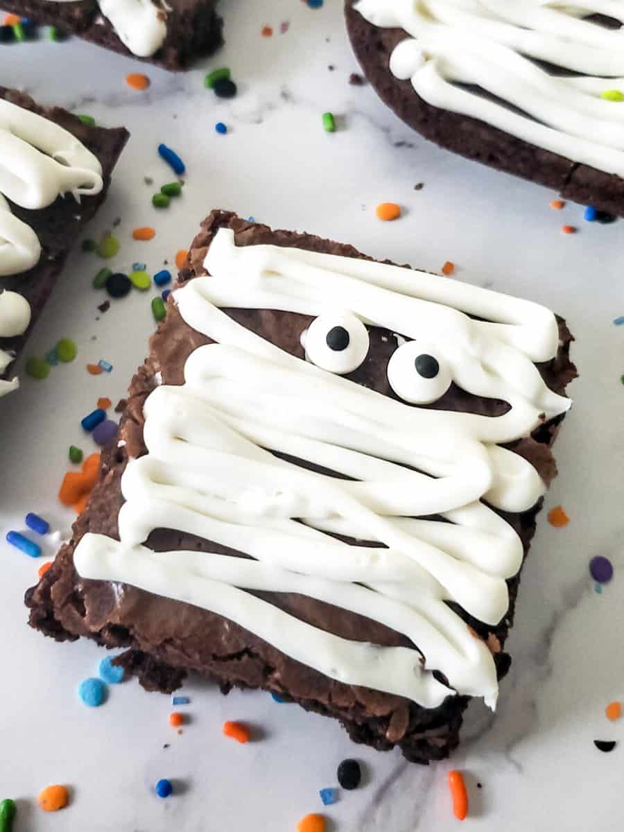 close up of a brownie decorated with white frosting for a brownie mummy.