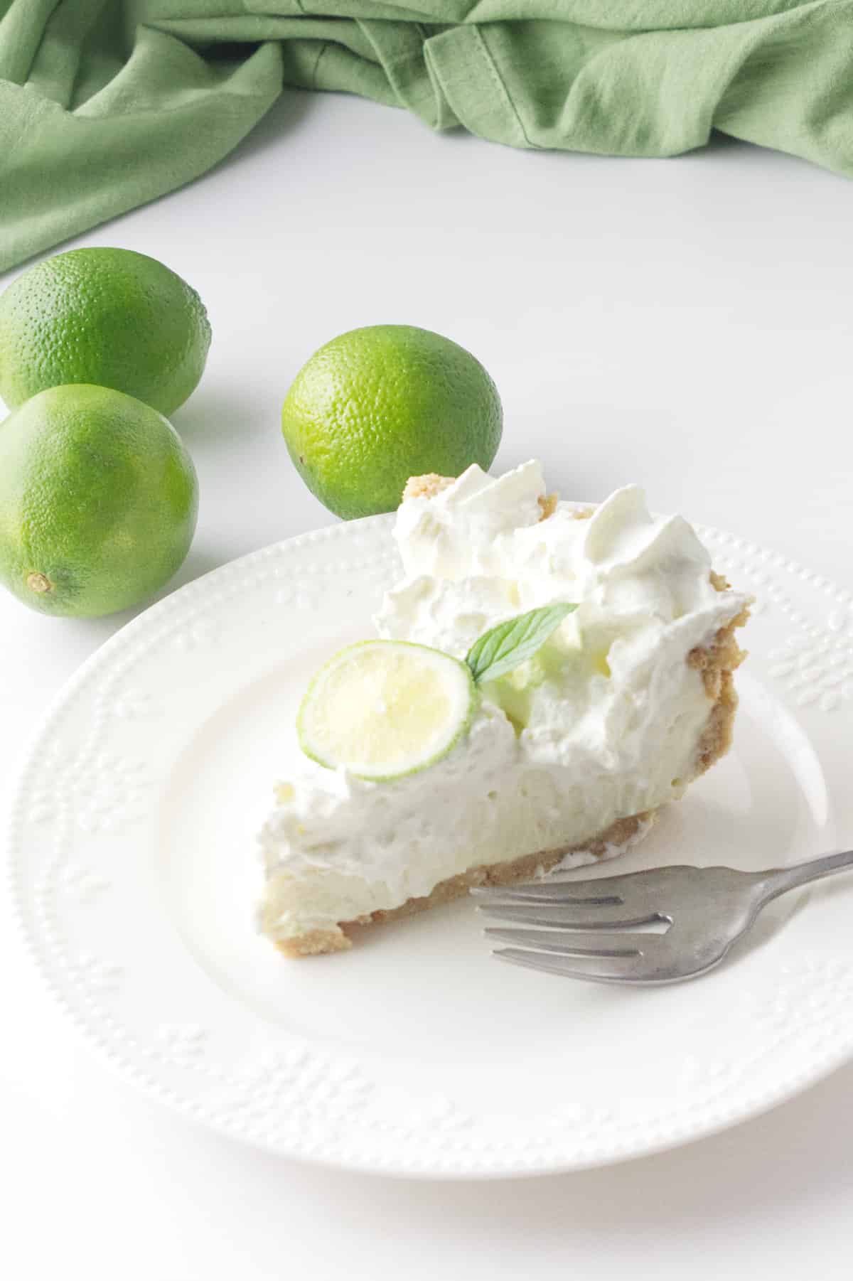 a slice of no bake key lime pie on a white plate.