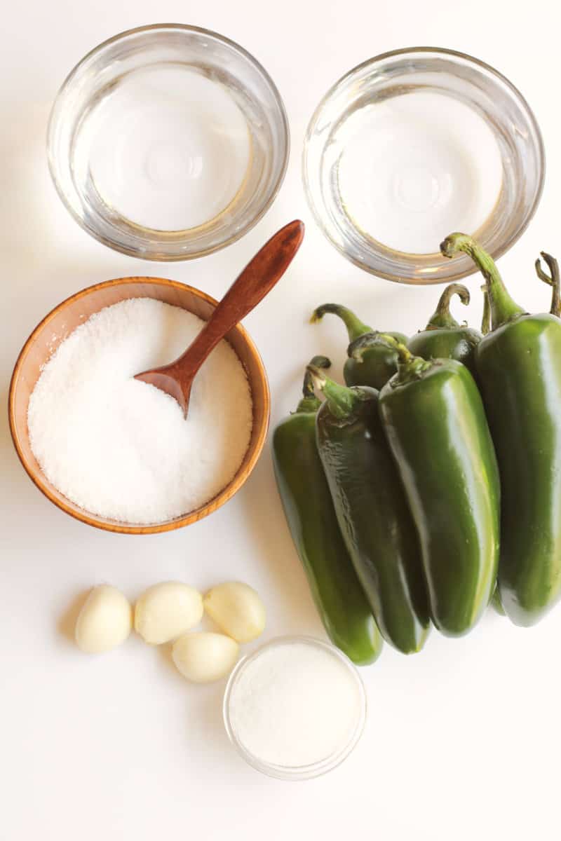 fresh jalapenos, salt, and garlic on a white counter.