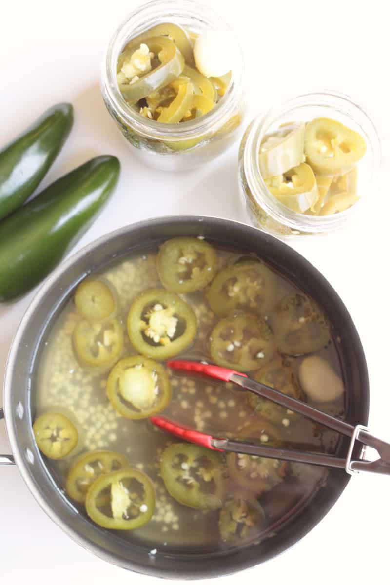 stainless steel pot with cooked sliced jalapenos.