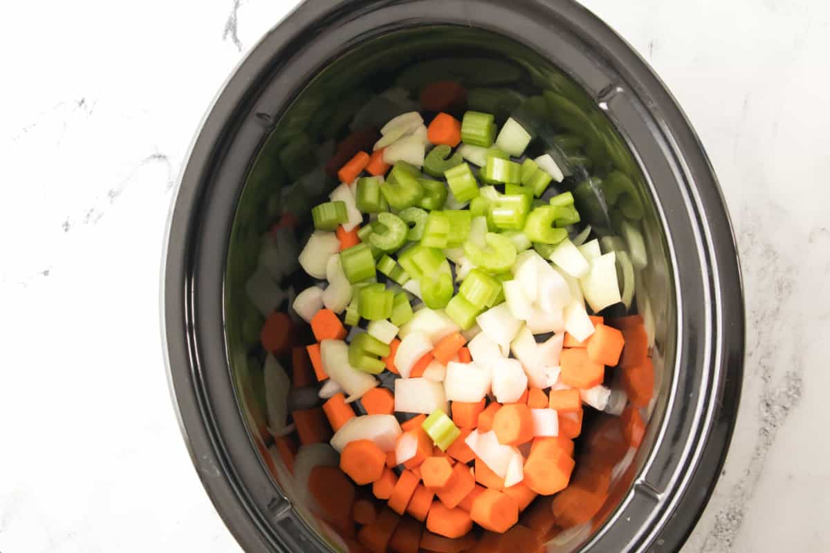 chopped celery, carrots, and onions in a slow cooker.