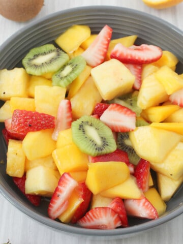 serving bowl full of slice tropical fruit salad.