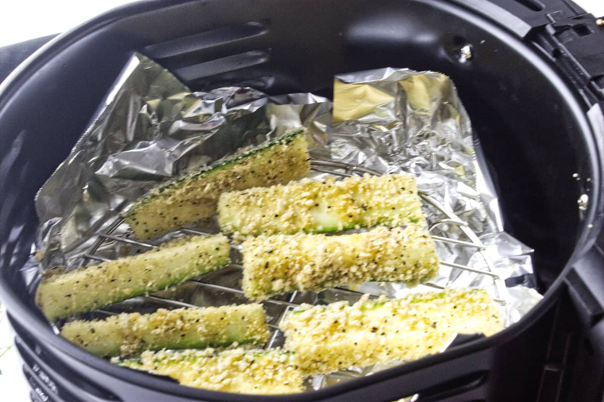 breaded zucchini sticks set into the air fryer.