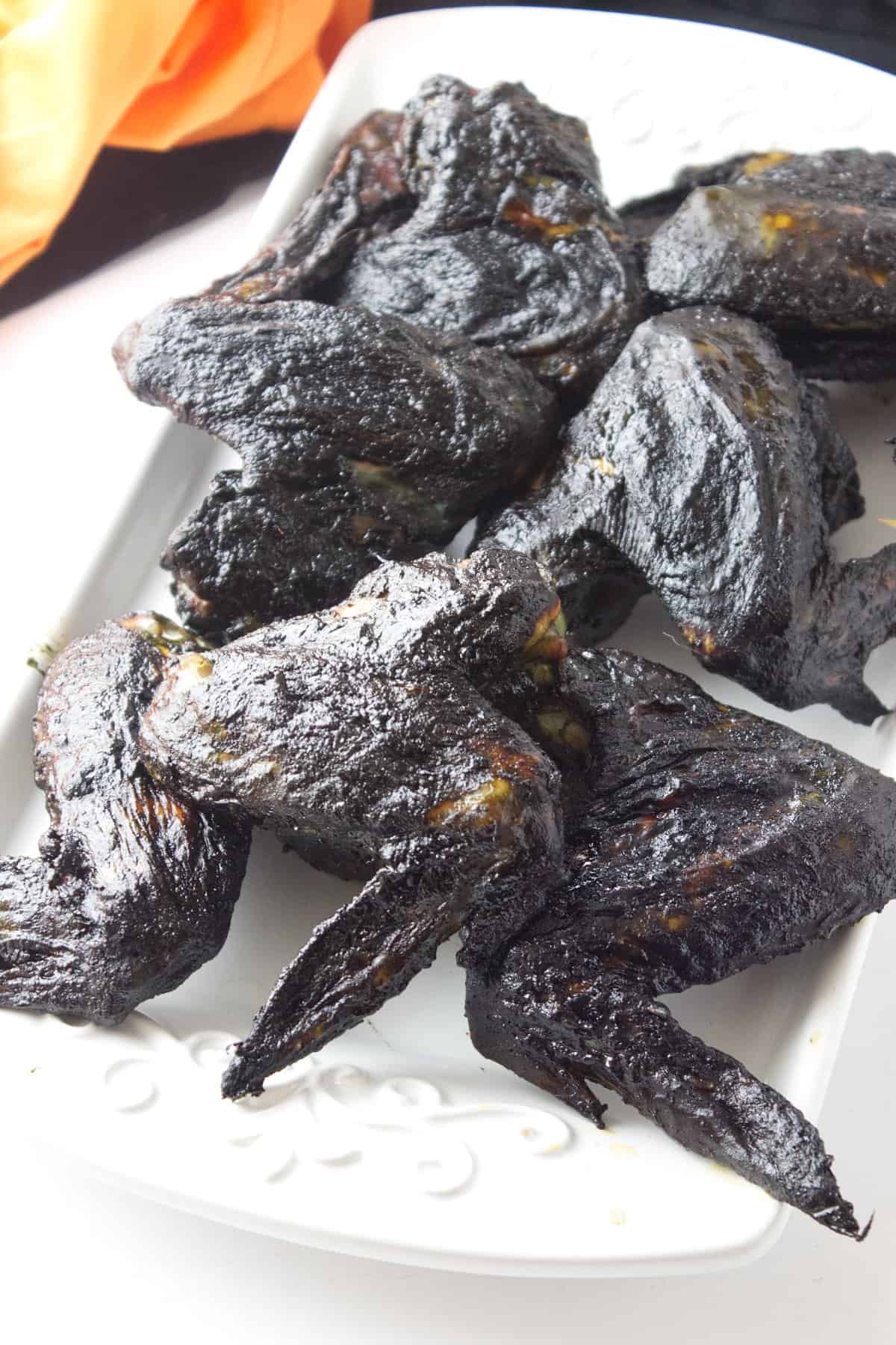 platter of black chicken 'bat wings' for halloween.