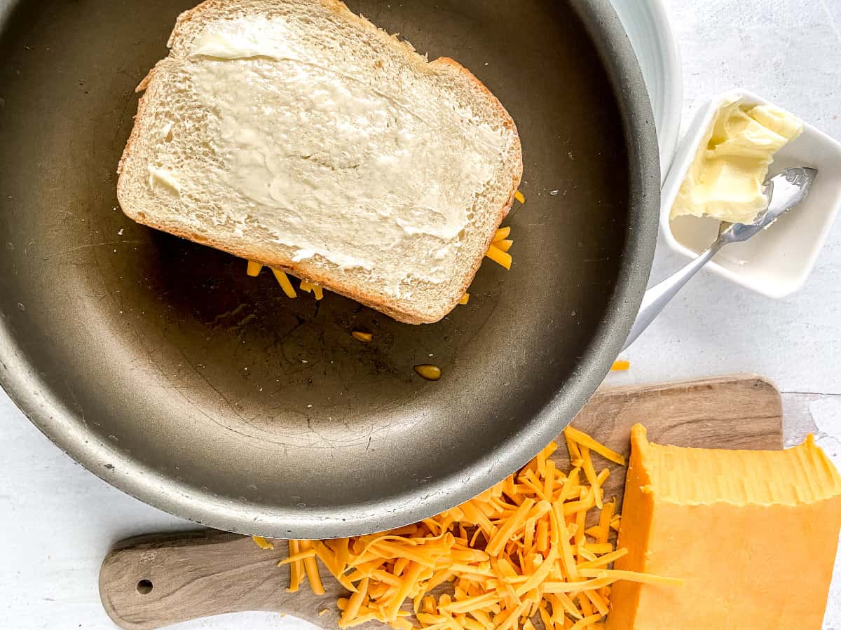 grilling buttered sandwich in a skillet.