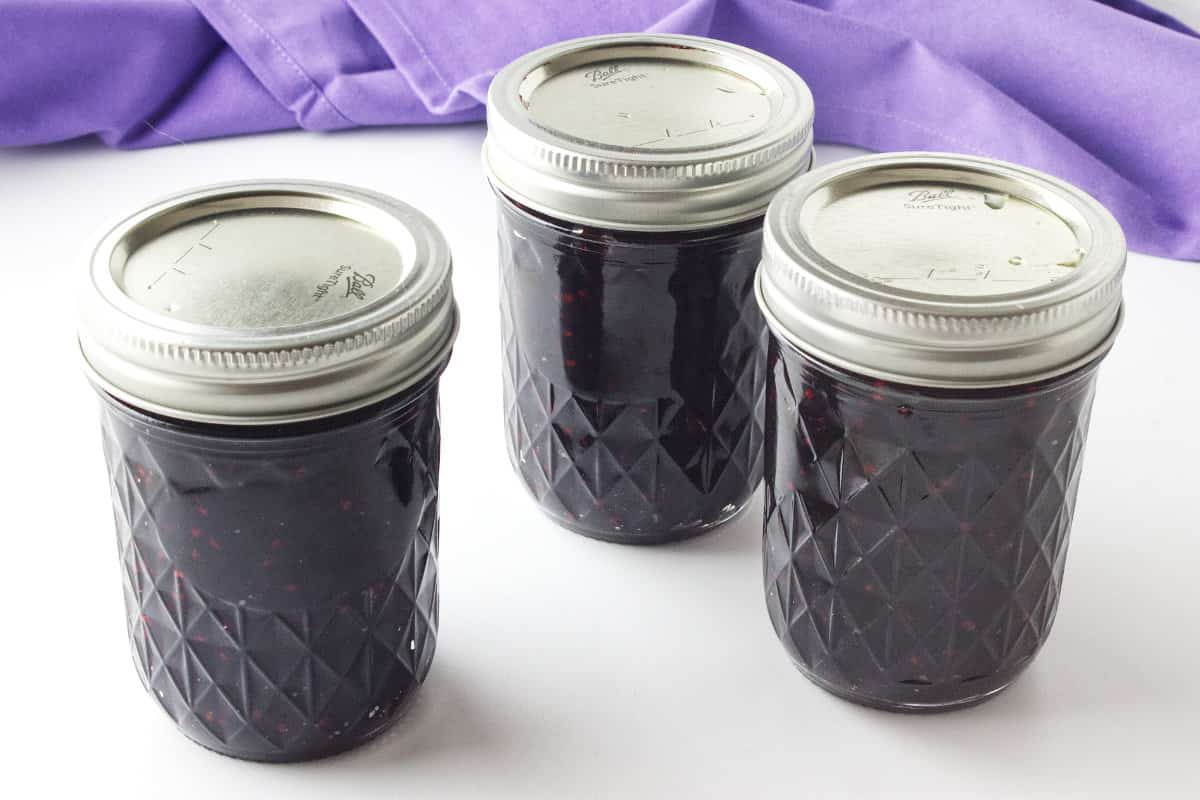 three ball canning jars filled with jam.