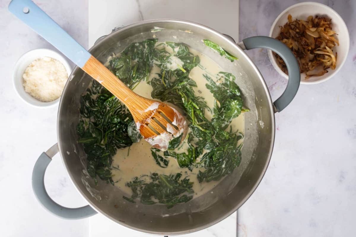 melted butter in pot of spinach.