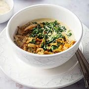 bowl of creamy spinach with fried onions on top.