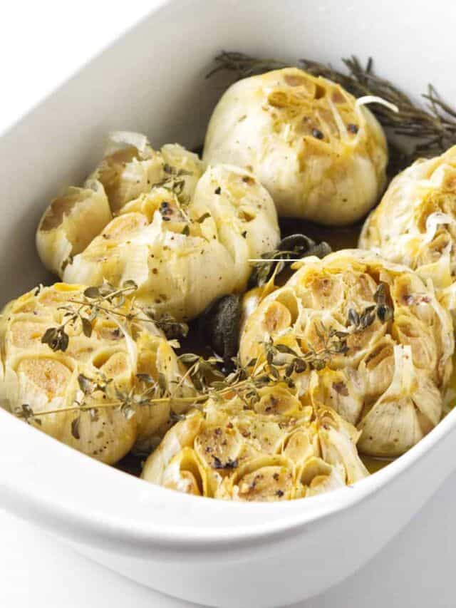 casserole baker with 6 roasted garlic cloves. Savory Halloween Party food idea.