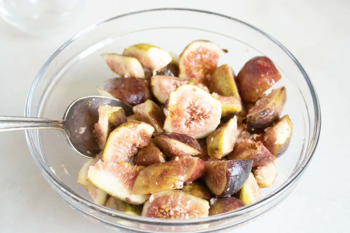 stirring bowl of figs with ingredients.