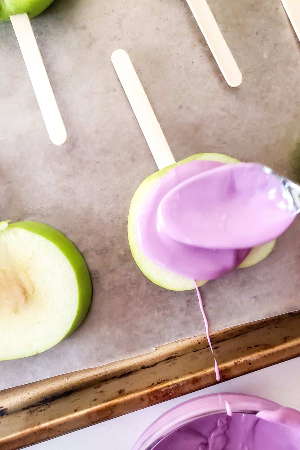melted purple candy on slices of green apple.