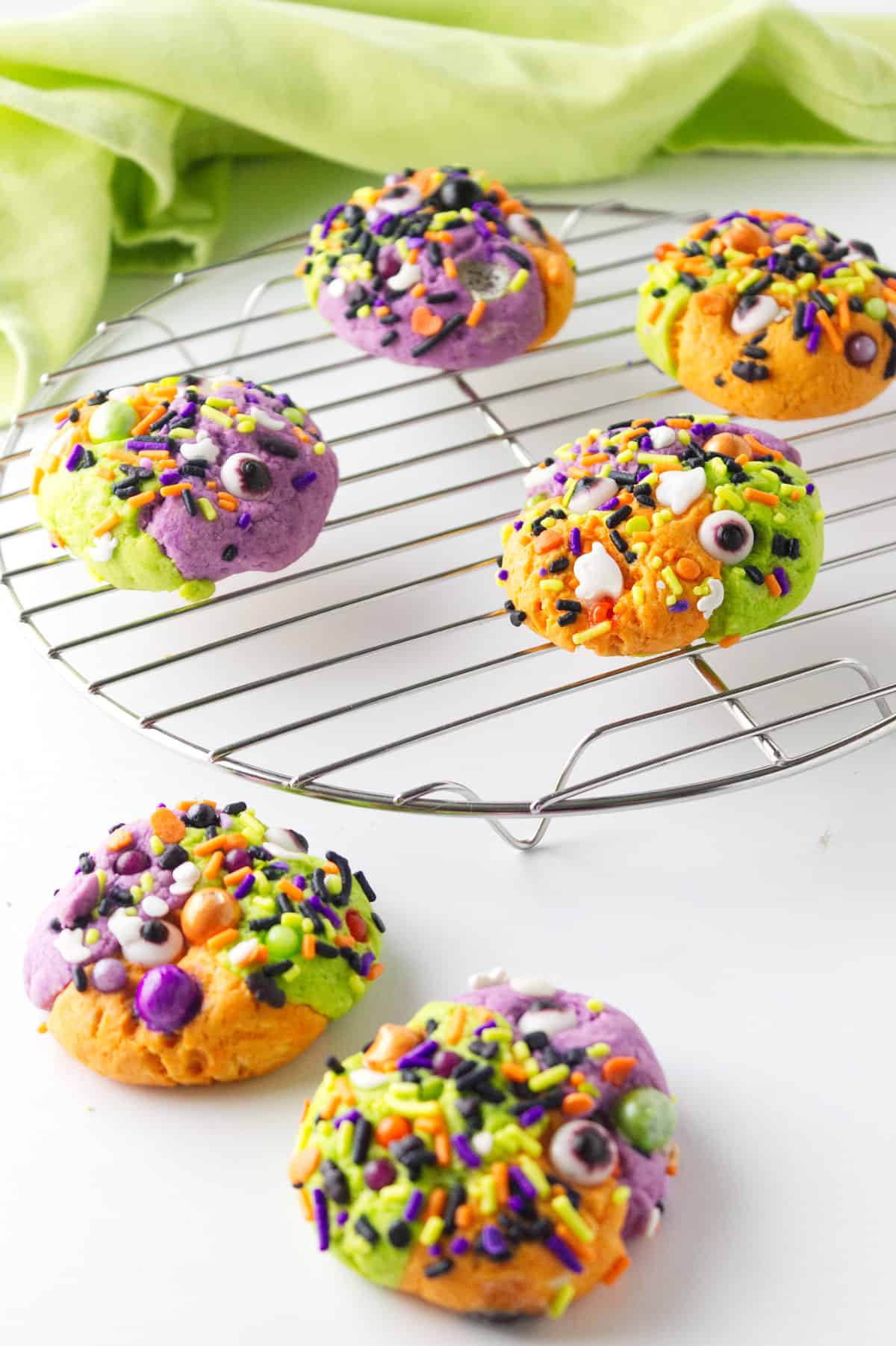 Three color hocus pocus cookies on a cooling rack.