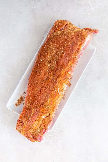 st. louis rib rub spread over raw pork ribs.