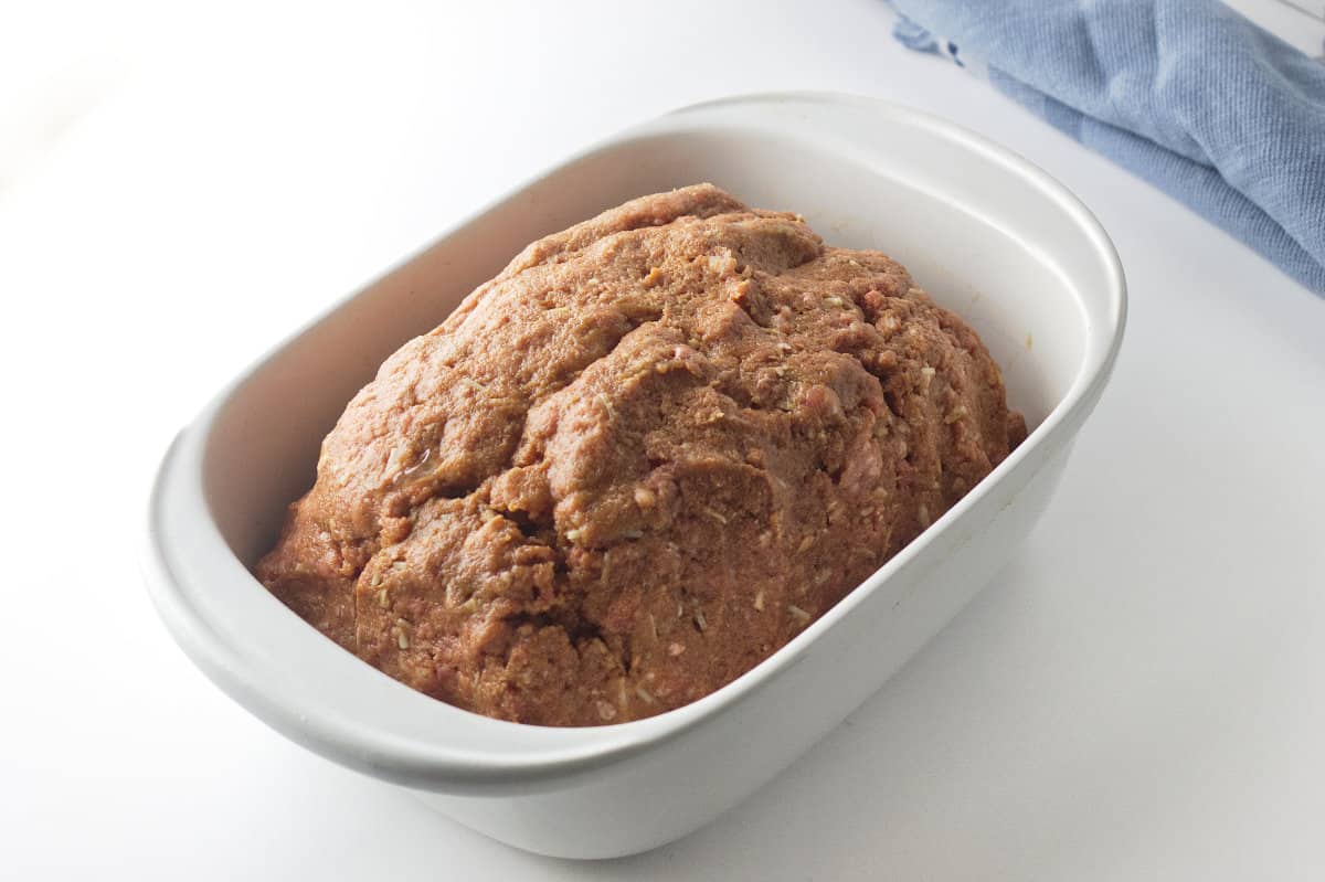 uncooked meatloaf in a baking dish.