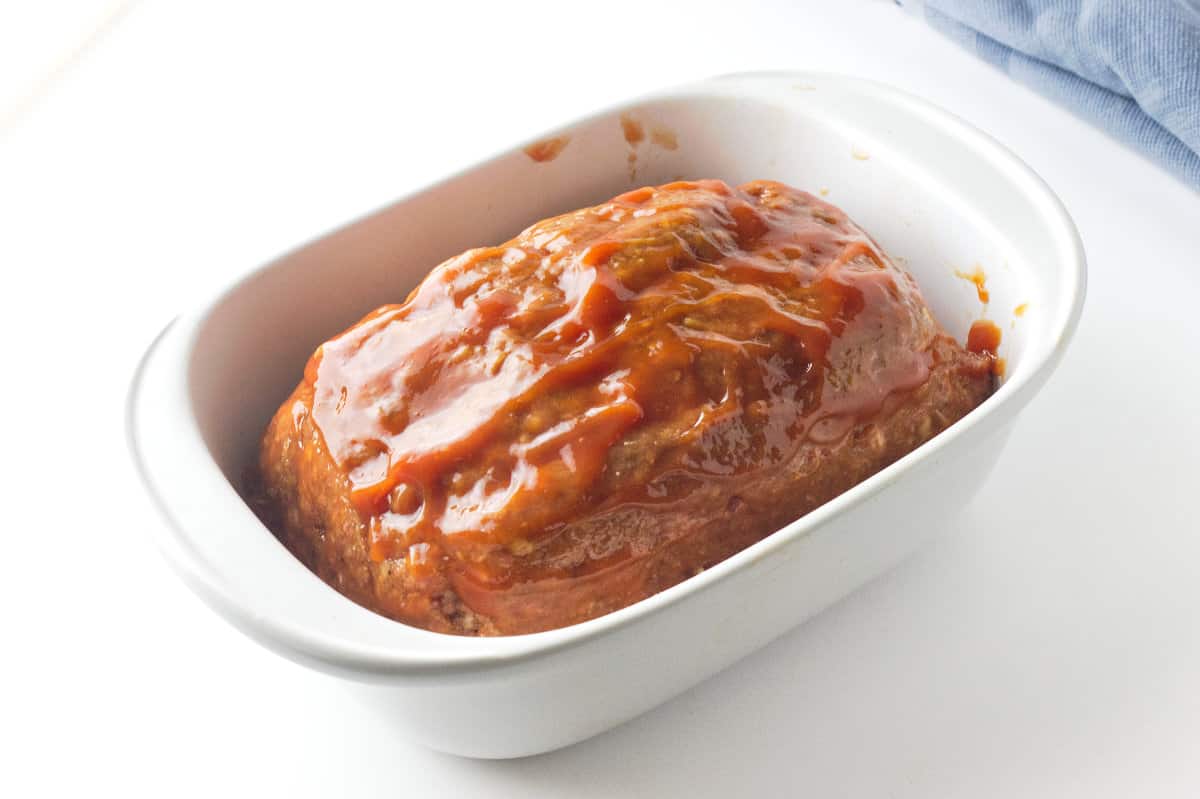 ketchup covered meatloaf in a baking dish.
