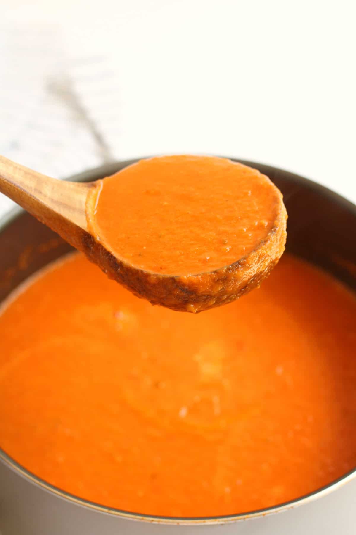 ladle of creamy tomato basil soup.