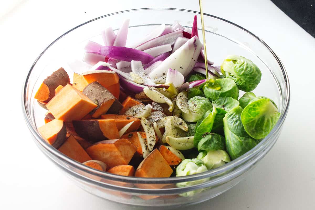 cut vegetables in a bowl with seasoning, oil and onion.