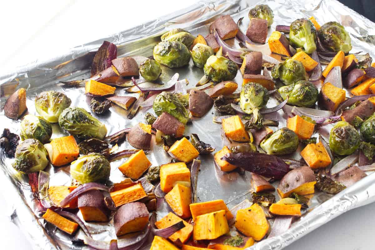 sweet potatoes and brussels sprouts on a cookie sheet.