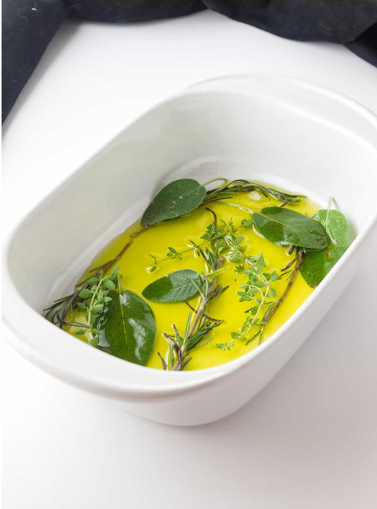 herbs infused in olive oil in a baker.