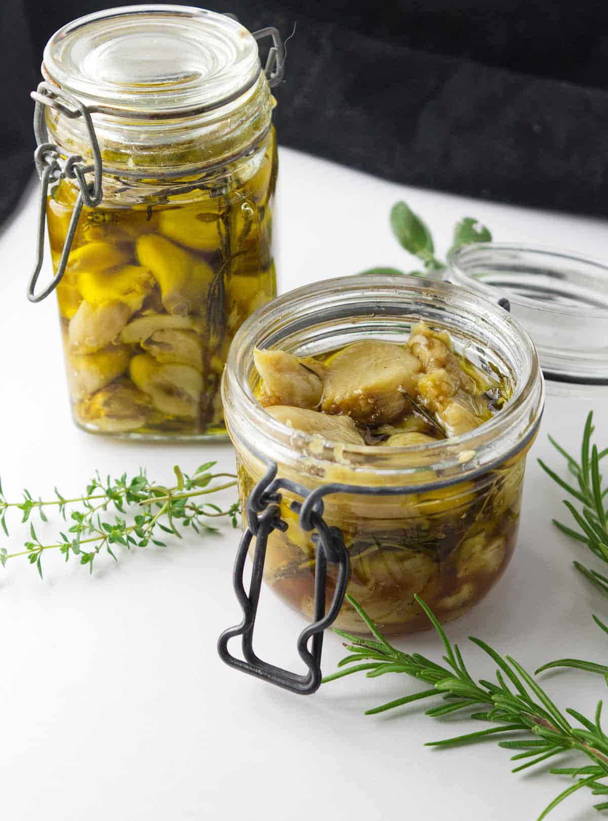 cloves of garlic in oil stored in jars.