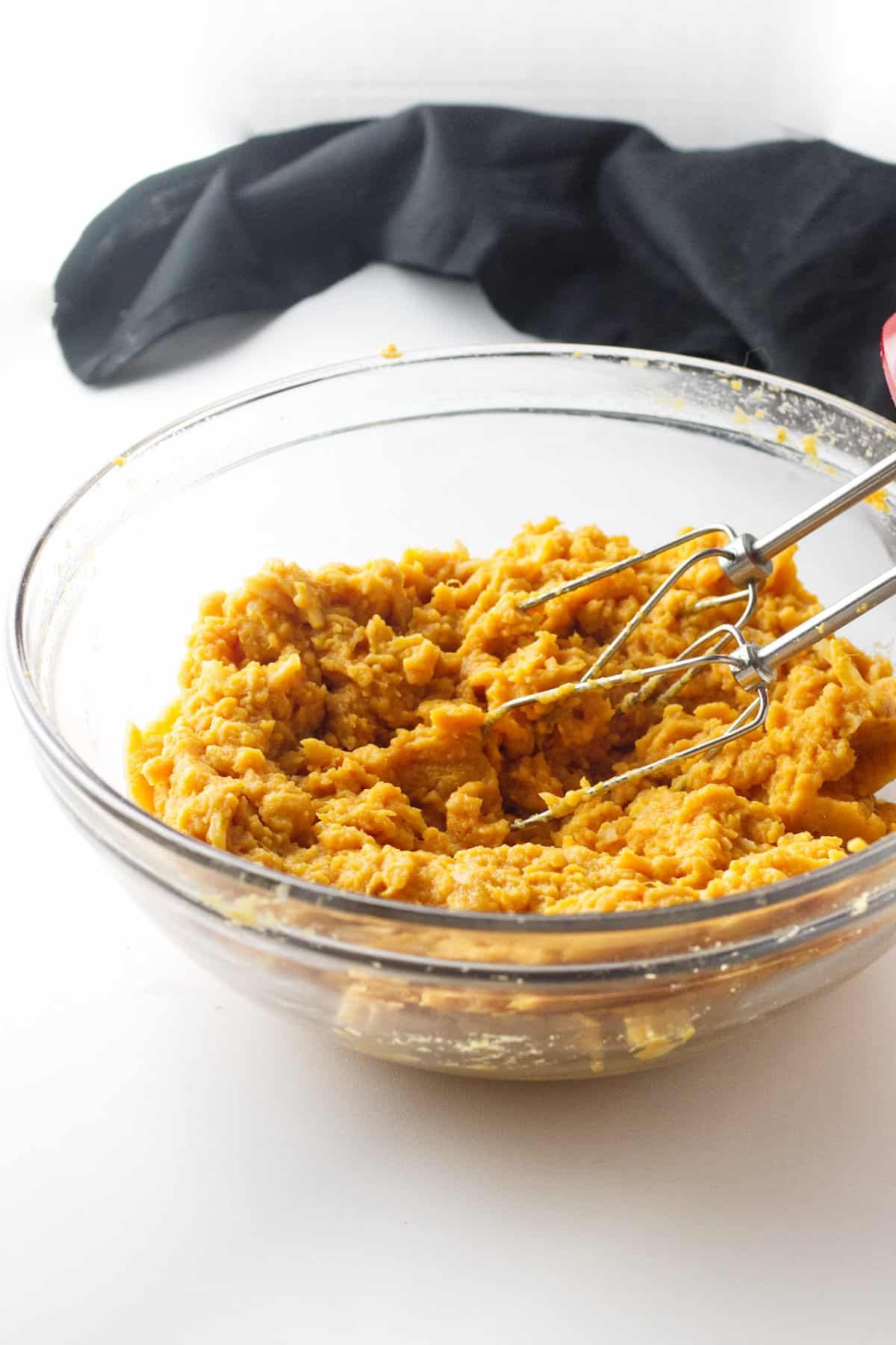 hand mixer in bowl of mashed sweet potatoes.