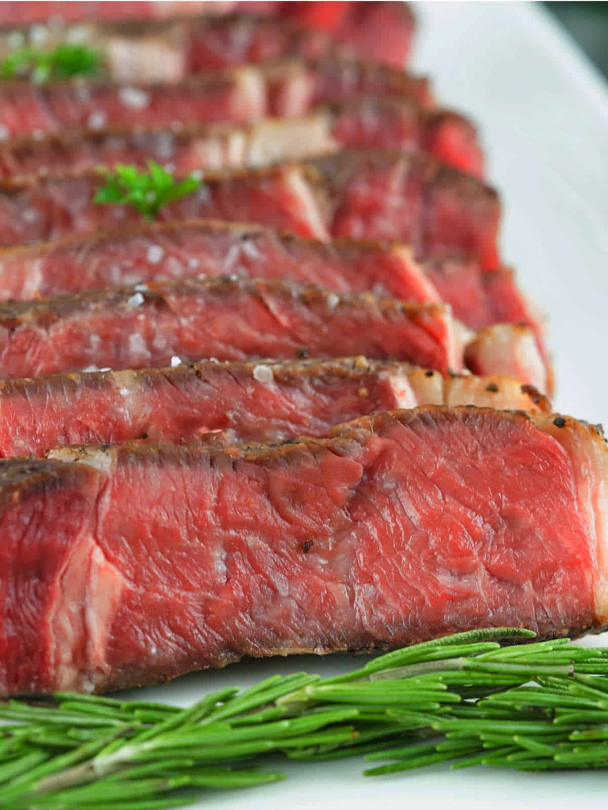 sliced rib eye steak on a platter.