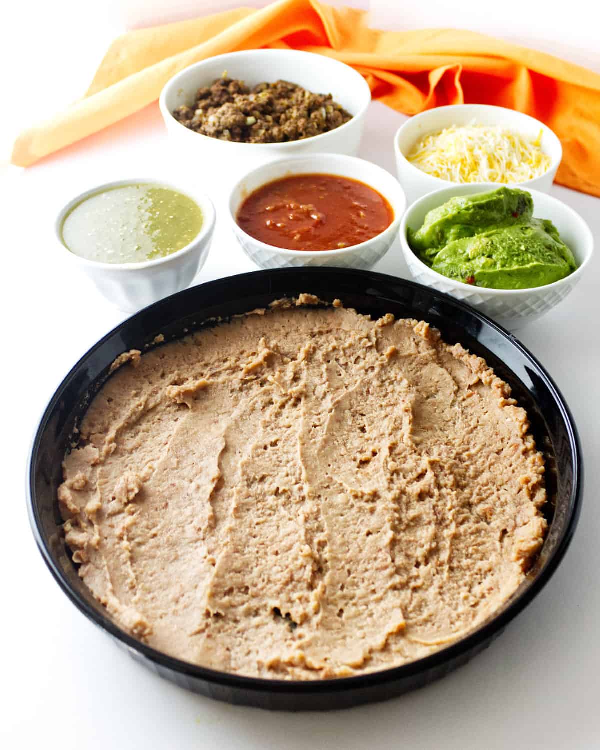 refried beans spread out in a dish.