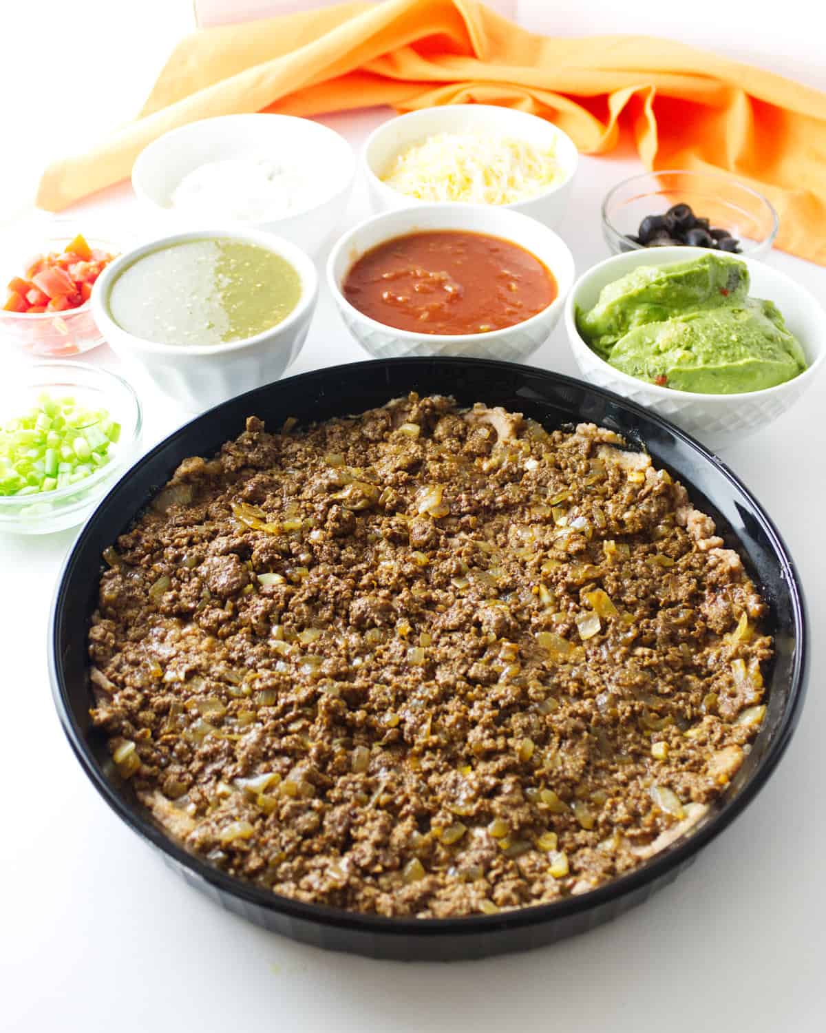 ground beef spread out in a dish.